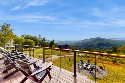 a deck with chairs and a view of the mountains at We'll Ski in Jackson