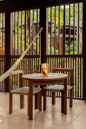 a wooden table and two chairs and a table and chairs at Boca de Agua Bacalar in Bacalar