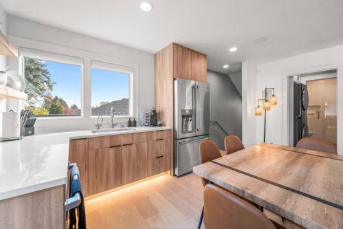 a kitchen with a wooden table and a refrigerator at Parkrose Heights Luxury Experience in Portland