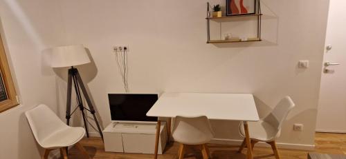 Cette chambre comprend une table et des chaises blanches. dans l'établissement Ville nice, à Nice