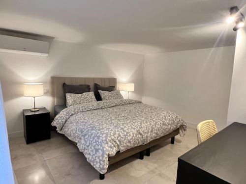 - une chambre avec un grand lit et 2 lampes dans l'établissement 9 Écluses-Canal du midi Logement entier T2 climatisé avec piscine, à Béziers
