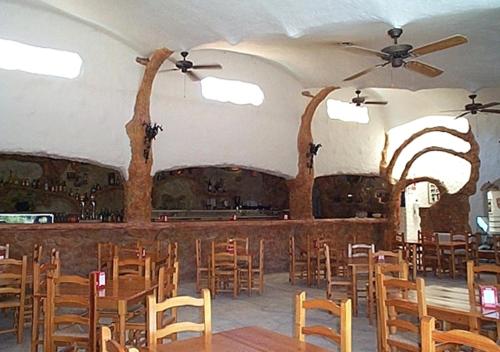 una sala da pranzo con tavoli e sedie in legno di Camping Bungalows Mariola a Bocairent