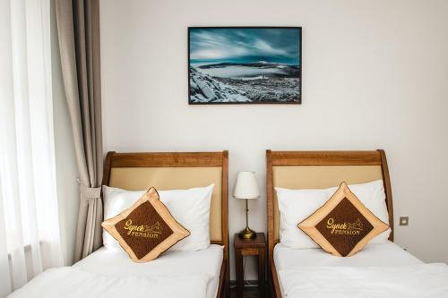 two beds sitting next to each other in a room at SYNEK Pension in Špindlerův Mlýn