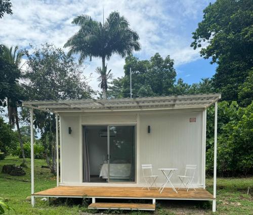 a tiny house with a porch and a table and chairs at Cautiva Sleep Inn in Guácimo