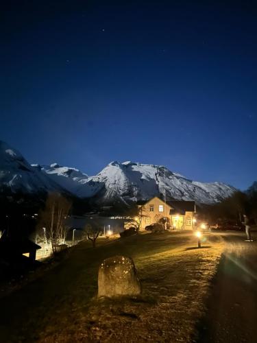 a house at night with a snow covered mountain at Vollsnes Feriehus in Hjelle