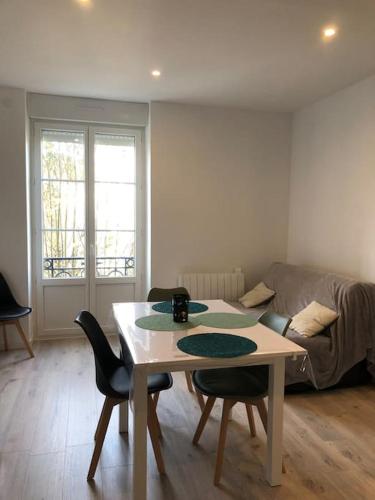 un salon avec une table, des chaises et un canapé dans l'établissement Appart 34m2 rénové , lumineux, à Vittel