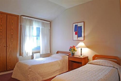 a hotel room with two beds and a window at Plaza Inn Week Inn in Campos do Jordão