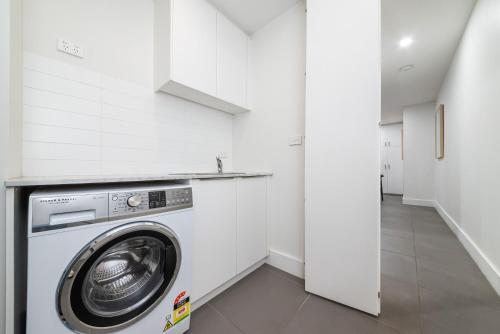 a laundry room with a washer and dryer at Piccolo by the Beach in Sandringham