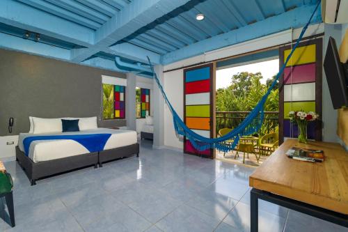 a bedroom with a bed and a balcony with a hammock at NQ Hotel Orinoquia in Villavicencio