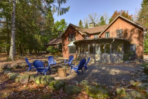 a house with blue chairs in front of it at The HYLANDS - Stunning Unique Mountain Home - Spa in Lake Harmony