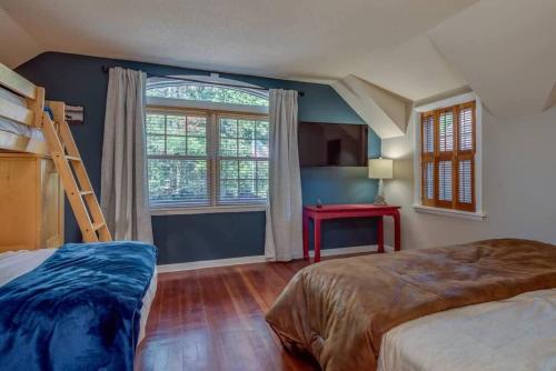 a bedroom with two bunk beds and a window at The HYLANDS - Stunning Unique Mountain Home - Spa in Lake Harmony