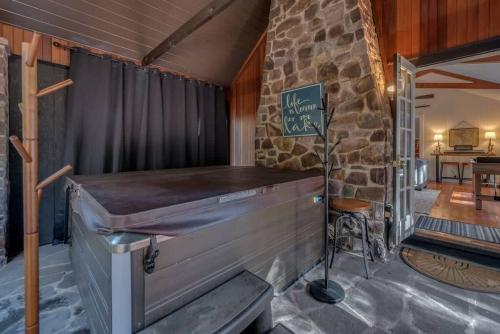 a bar in a room with a stone wall at The HYLANDS - Stunning Unique Mountain Home - Spa in Lake Harmony