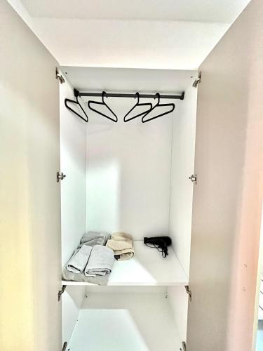 a white closet with black hangers and shoes at BAM BAM TIBURTINA Guesthouse in Rome