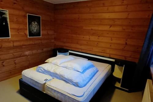 a bed in a room with wooden walls at Vakantievilla Värmland, Zweden in Filipstad