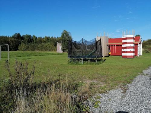 a field with a tent and a building at Vakantievilla Värmland, Zweden in Filipstad