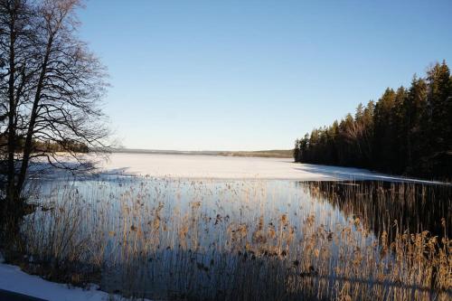 a large body of water with trees and snow at Vakantievilla Värmland, Zweden in Filipstad