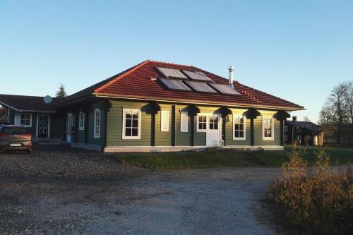 a green house with a red roof at Vakantievilla Värmland, Zweden in Filipstad
