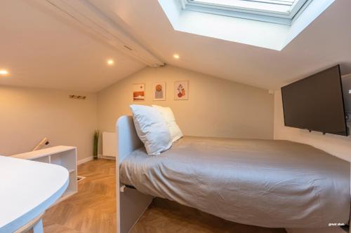 une chambre avec un lit et une télévision à écran plat dans l'établissement Montsejour - Magnifique studio neuf, à Toulouse