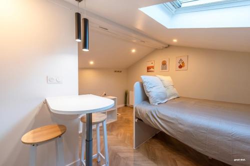 une petite pièce avec un lit et une table dans l'établissement Montsejour - Magnifique studio neuf, à Toulouse