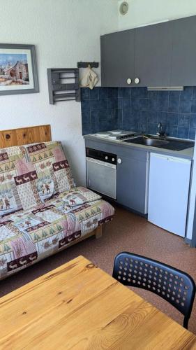 a small kitchen with a couch and a table in a room at Résidence Le Plein Soleil 2 - Studio 4 personnes, résidence Plein Soleil 2 à ORCIERES-MERLETTE, Alpes du Sud MAE-7574 in Orcières