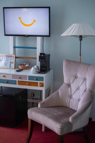a living room with a chair and a tv at Paj Hotelul Retreat & Spa in Sinaia
