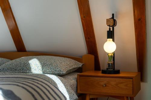 a lamp on a night stand next to a bed at Vila Sun forest in Žabljak
