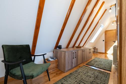 a room with a green chair and a cabinet at Vila Sun forest in Žabljak