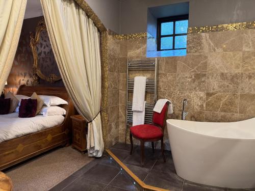 a bathroom with a tub and a bedroom with a bed at Winteringham Fields in Winteringham