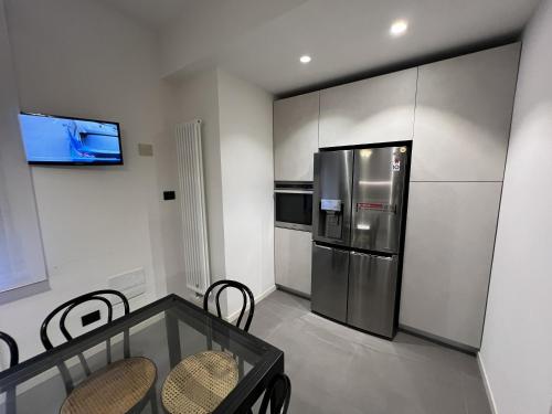 a kitchen with a stainless steel refrigerator and a table at Icaro 1 Apartment in Verona