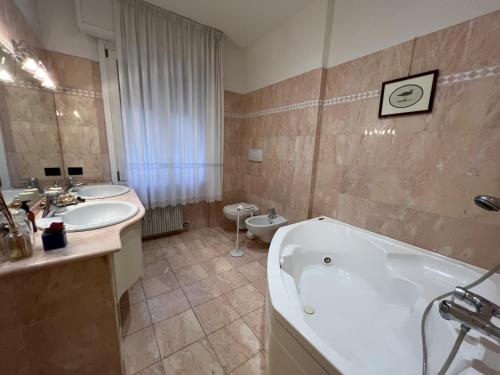 a bathroom with two sinks and a tub and a toilet at Icaro 1 Apartment in Verona