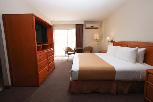 a hotel room with a bed and a flat screen tv at Gamma Durango Plaza Vizcaya in Durango