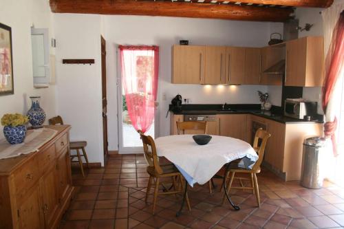 une cuisine avec une table et des chaises dans une pièce dans l'établissement Petit mas en Provence superbe vue, à Istres