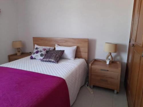 a bedroom with a bed with purple sheets and pillows at Modern apartment in Vilamoura with shared pool in Vilamoura