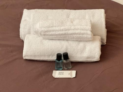 a couple of towels and a bottle of lotion on a bed at Icaro 1 Apartment in Verona