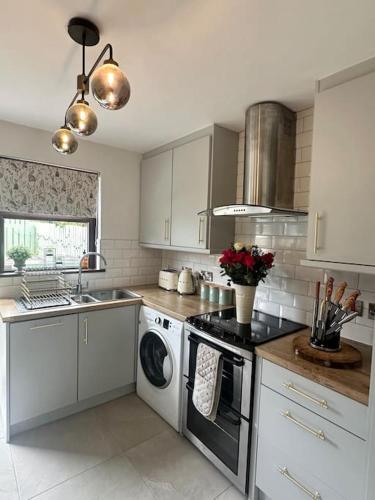 a kitchen with white cabinets and a washer and dryer at Royal Hillsborough Hideaway in Hillsborough