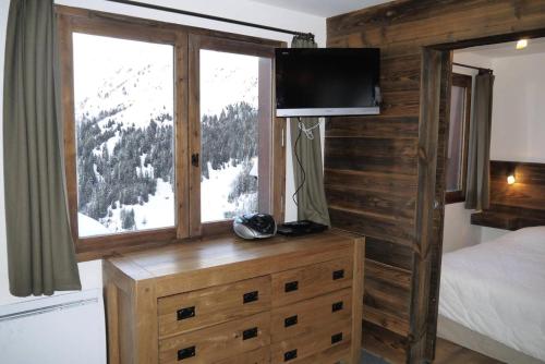 - une chambre avec un lit et une fenêtre avec une télévision dans l'établissement Résidence Cembros - CEMBROS 31 MAE-6251, à Les Allues