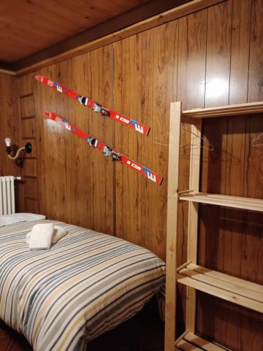 a bedroom with a bed and a wooden wall at Chalet del Lago Laceno in Villaggio Laceno