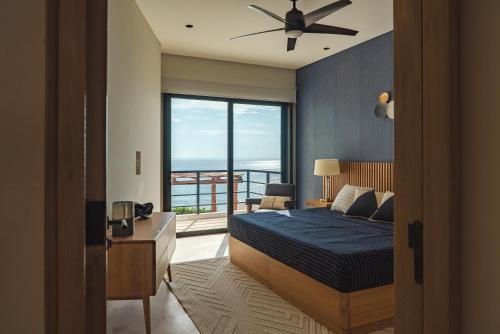 a bedroom with a bed and a large window at Sierra Mar in Isla Mujeres