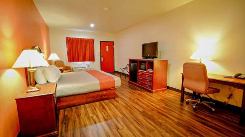 a hotel room with a bed and a desk and a computer at Motel 6-Atoka, OK in Atoka