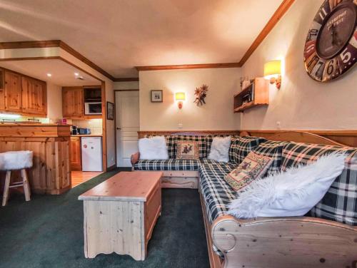 un salon avec un canapé et une horloge au mur dans l'établissement Résidence Valeriane G - VALERIANE 210 MAE-7171, à Valmorel