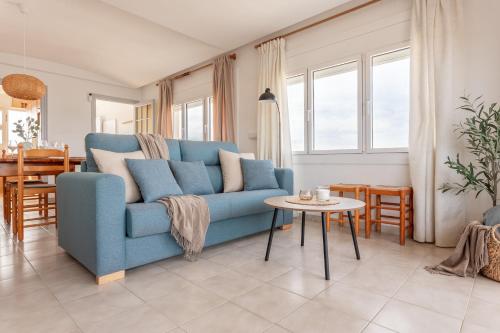 a living room with a blue couch and a table at Apartamento Blaucel in L'Escala