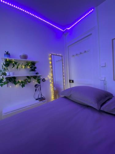- une chambre dotée d'un lit avec des lumières violettes dans l'établissement Cute little apartment, à Neuilly-sur-Seine
