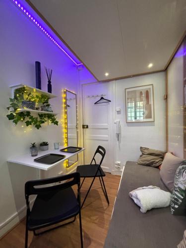 un salon avec un canapé et une table avec des chaises dans l'établissement Cute little apartment, à Neuilly-sur-Seine