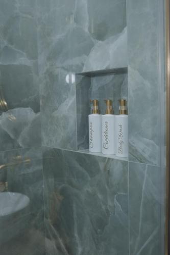 three bottles ofodorizers sitting on a shelf in a bathroom at Butera 505-Luxury Suites in Bagheria