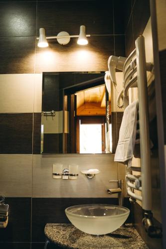 a bathroom with a sink and a mirror at Rich OAK - готель з відкритим панорамний басейном in Yablunytsya