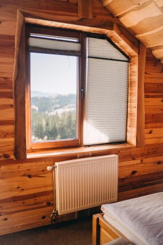 a room with a window and a radiator in a room at Rich OAK - готель з відкритим панорамний басейном in Yablunytsya