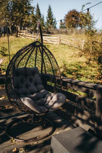 a swing chair sitting on a porch at Rich OAK - готель з відкритим панорамний басейном in Yablunytsya