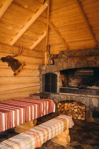 a room with a fireplace in a log cabin at Rich OAK - готель з відкритим панорамний басейном in Yablunytsya