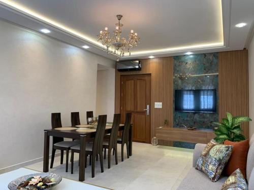 Appartement moderne avec vue panoramique في أغادير: غرفة طعام مع طاولة وكراسي سوداء