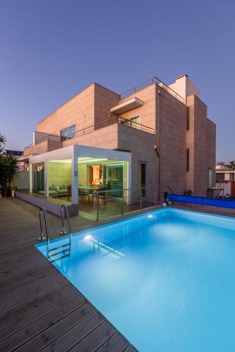 a swimming pool in front of a house at Sunset Villa in Labruge